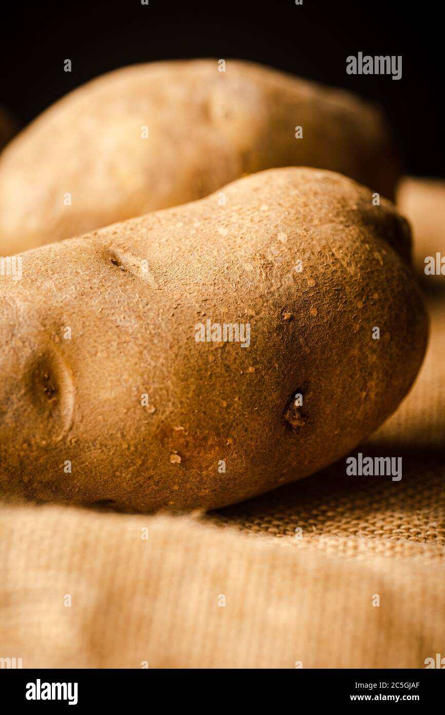 Fresh Potatoes on a rag with dark background Stock Photo - Alamy