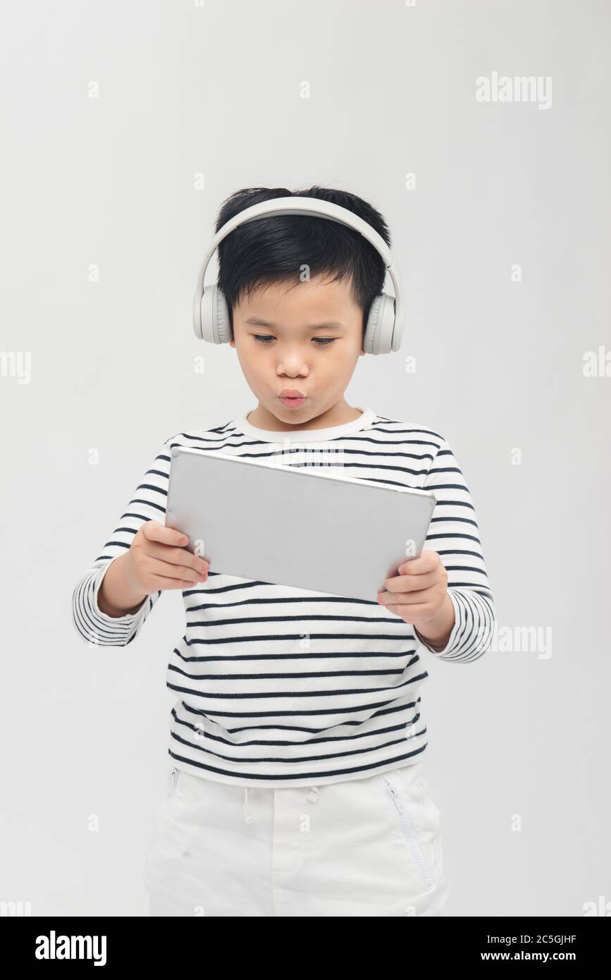 Asian boy laying tablet computer with headset Stock Photo