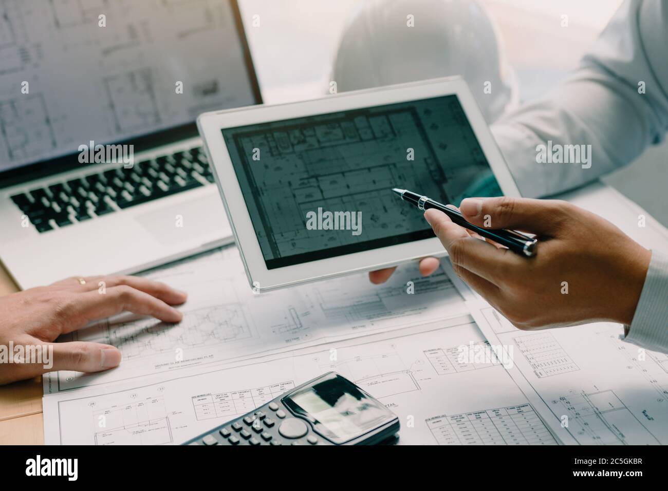 Two engineering working together and using digital tablet looking ...