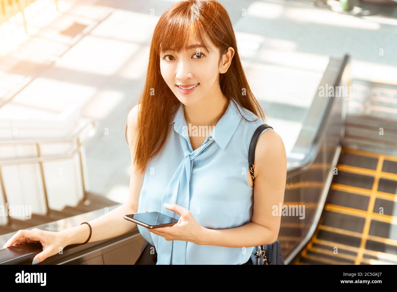 young business Woman Going To Work and holding the  mobile Phone Stock Photo