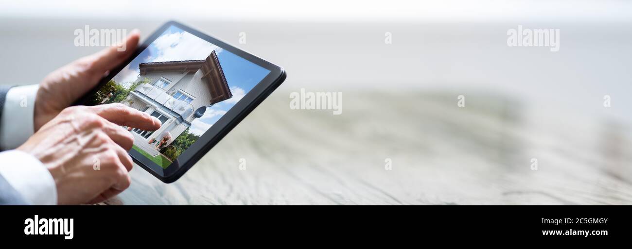 Man Selecting Home On Digital Tablet Using Touchscreen Stock Photo