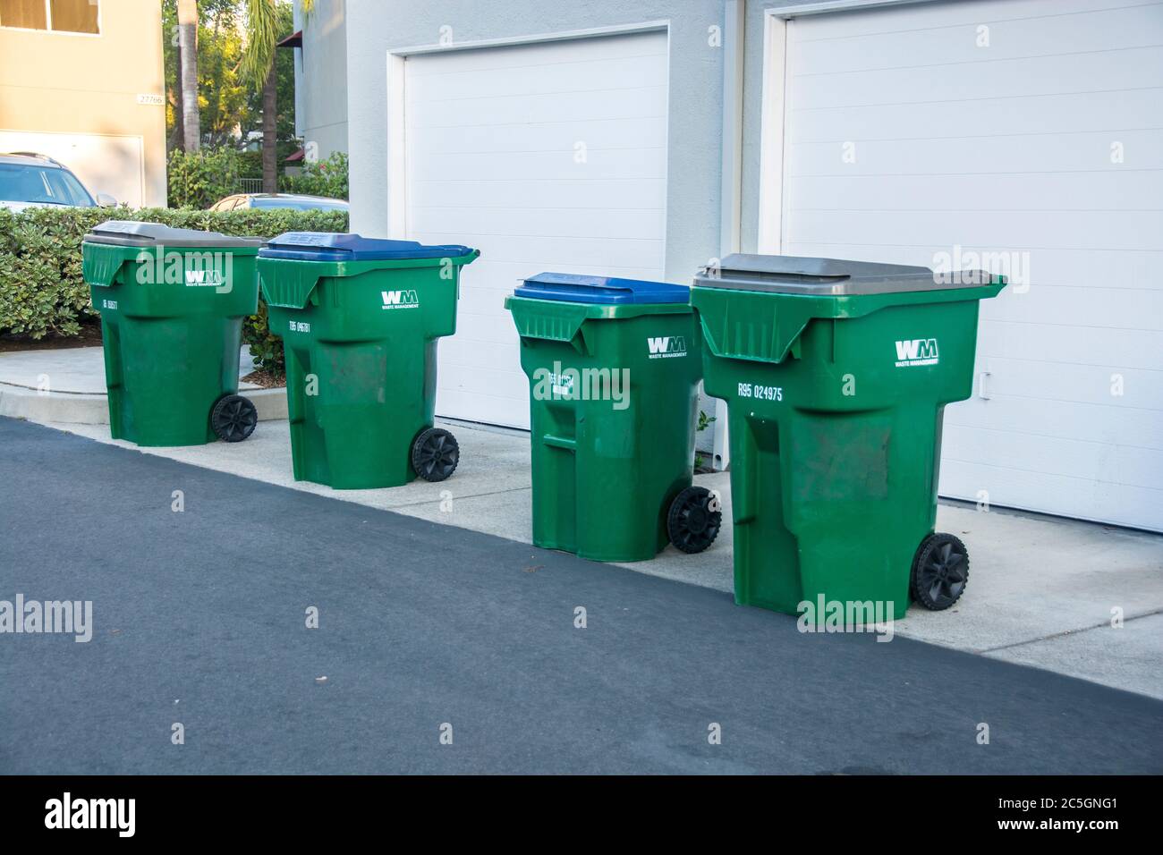 A row of trashcans. Green cans are for items deemed appropriate to recycle . Stock Photo