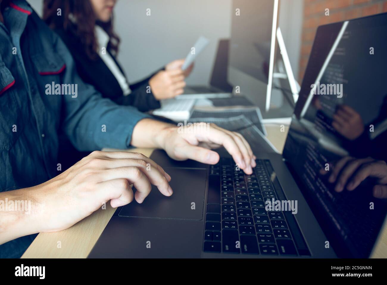 Two partnerships developing programming and coding technologies working on laptop and analyzing together. Stock Photo