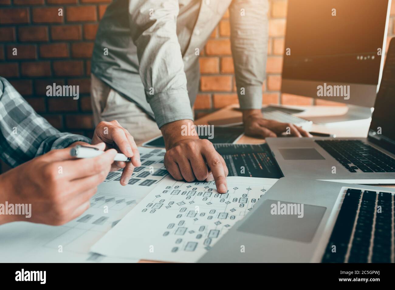 Two software developers are analyzing together about the code written into the program on the computer. Stock Photo