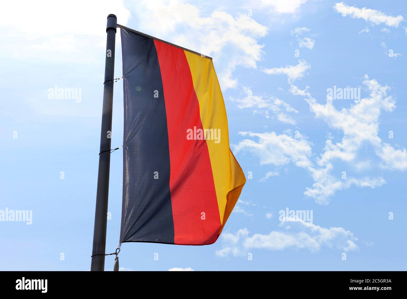 Deutsche Nationalfahne vor blauem Himmel Stock Photo