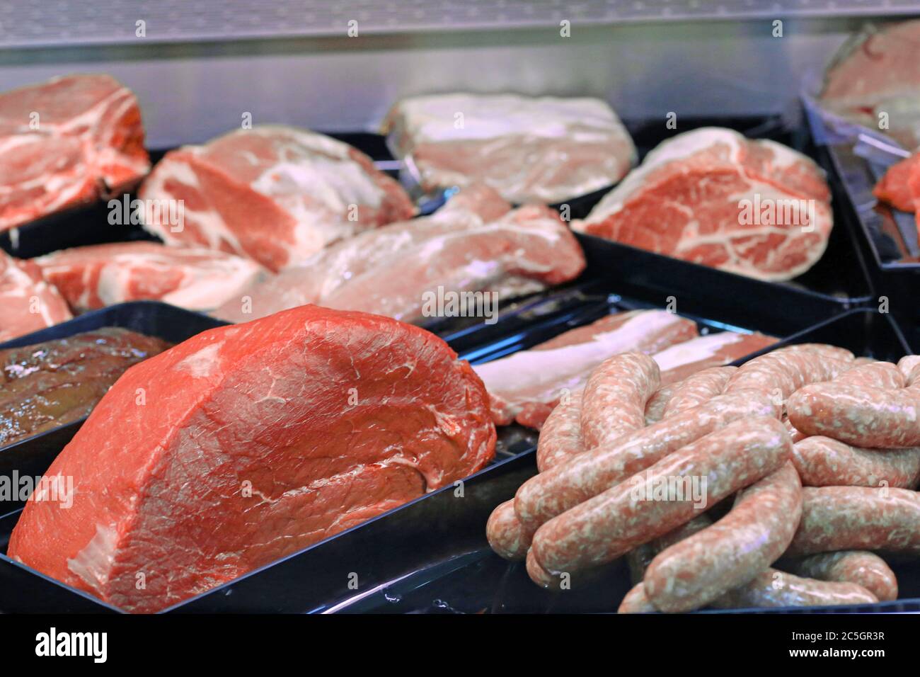 Variation feiner Fleischwaren in der Metzgerei (Variety of fine meat products in the butchery) Stock Photo