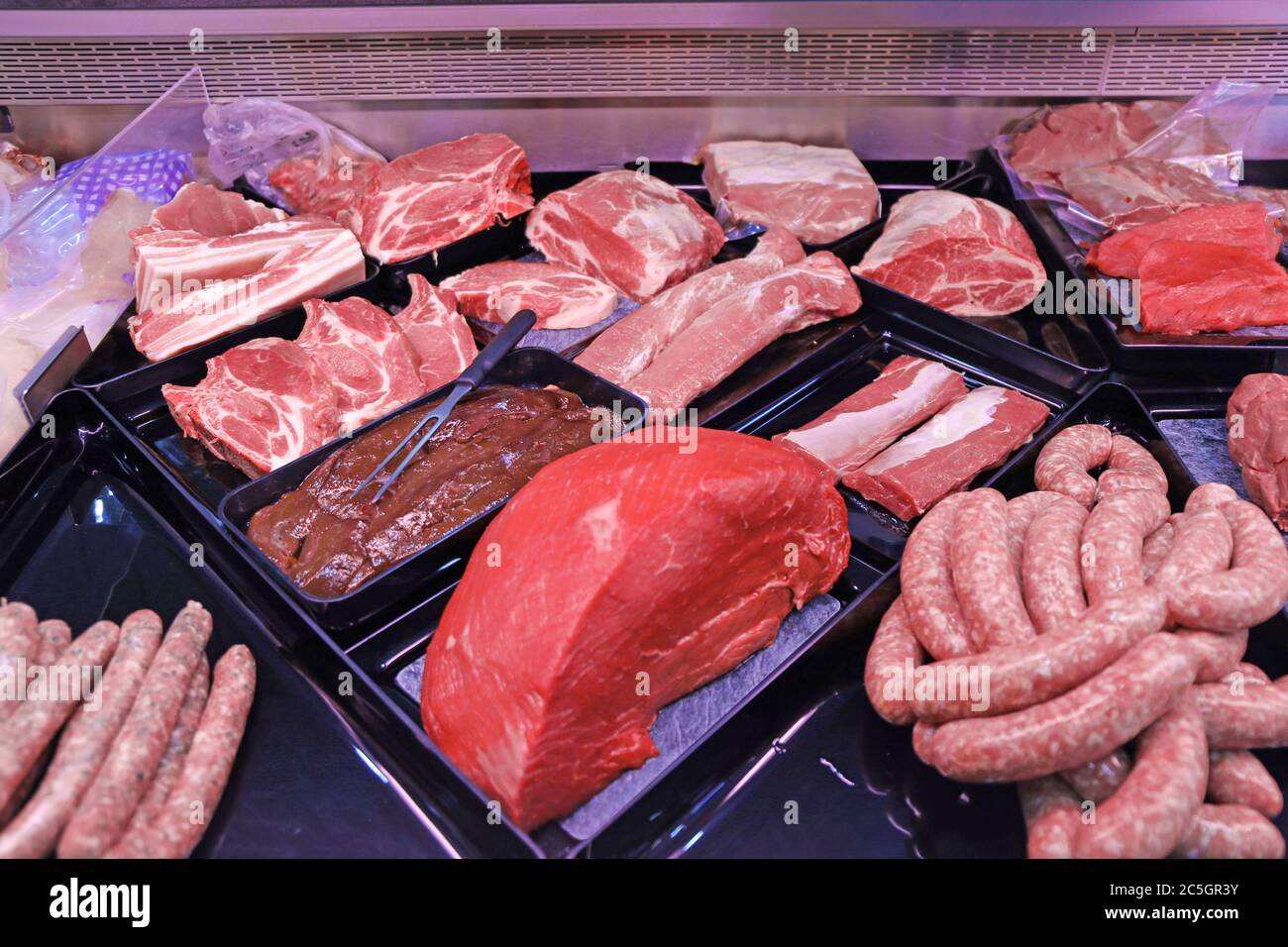 Variation feiner Fleischwaren in der Metzgerei (Variety of fine meat products in the butchery) Stock Photo