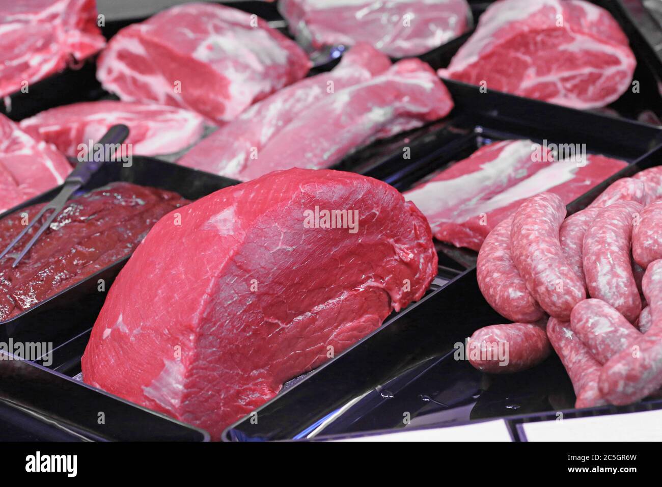 Variation feiner Fleischwaren in der Metzgerei (Variety of fine meat products in the butchery) Stock Photo