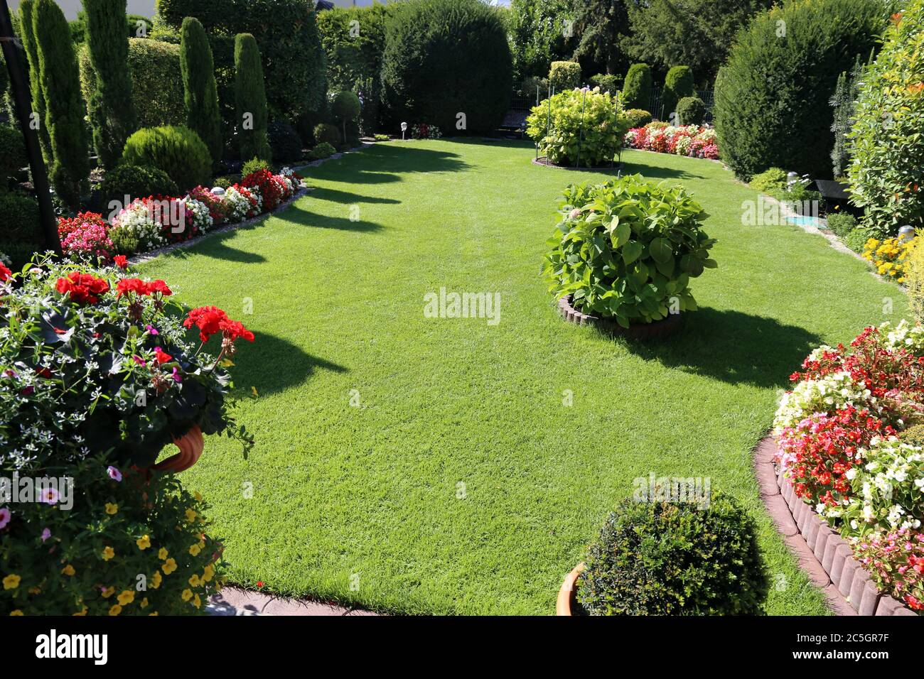 Gepflegte Gartenanlage mit Rasen und Blumen (Neat and tidy garden with