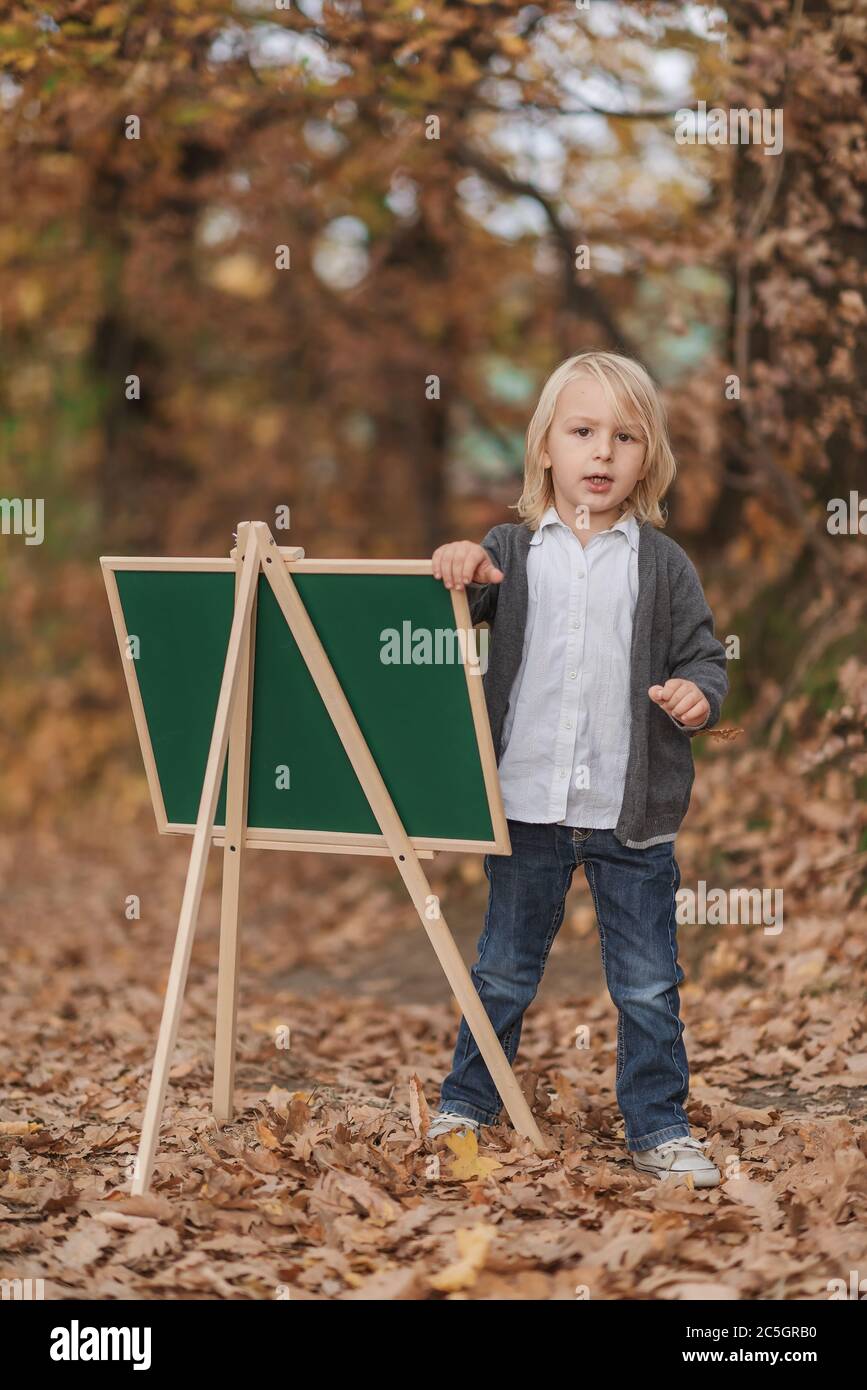 boy writes on a chalkboard outside Stock Photo - Alamy