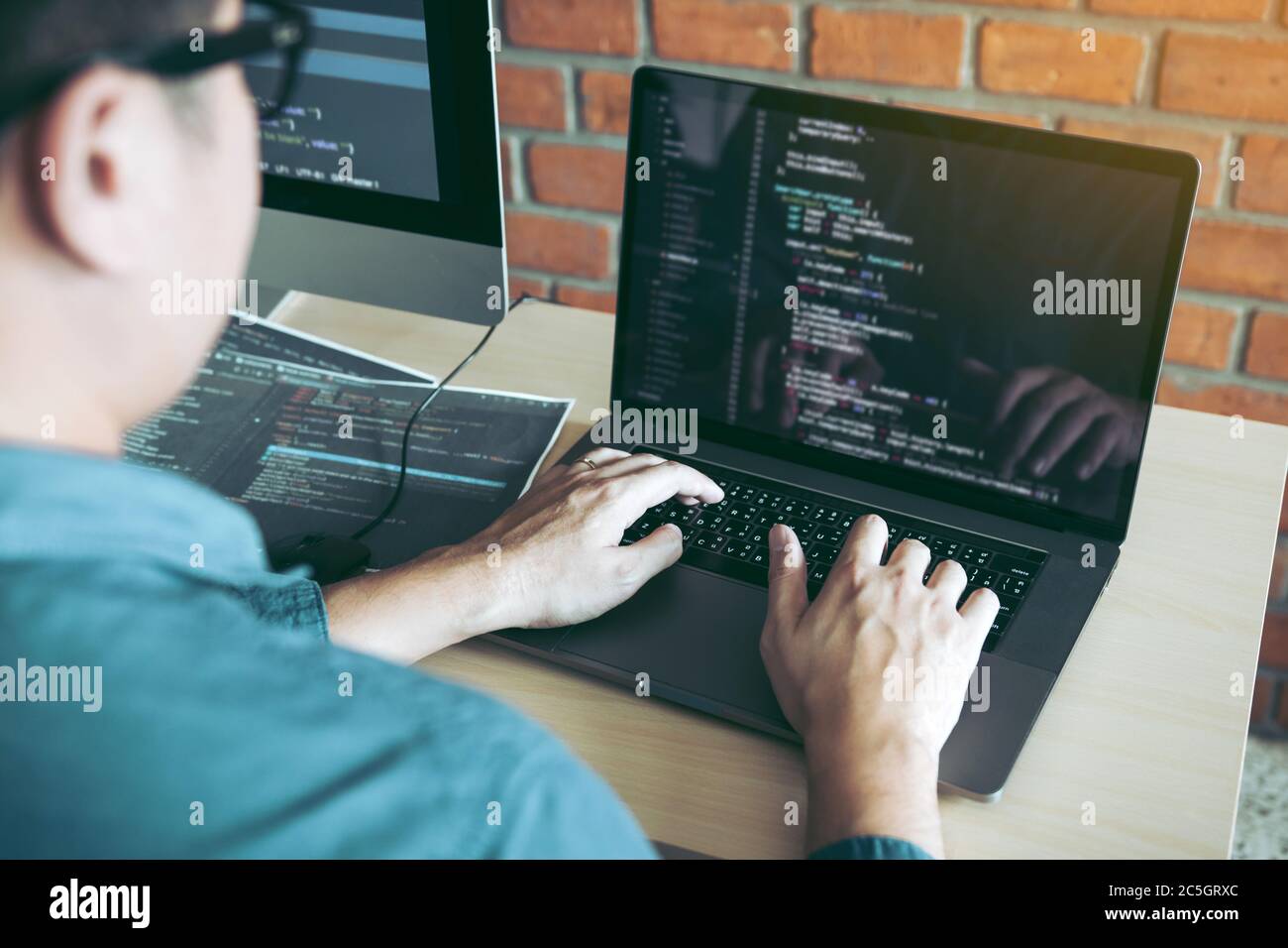 Two partnerships developing programming and coding technologies working on laptop and analyzing together. Stock Photo