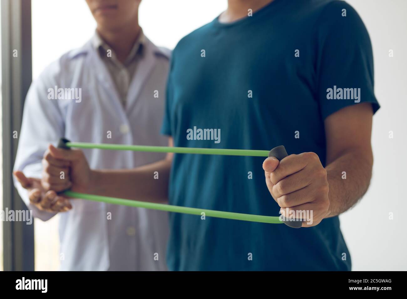 Patient doing stretching exercise with a flexible exercise band and a