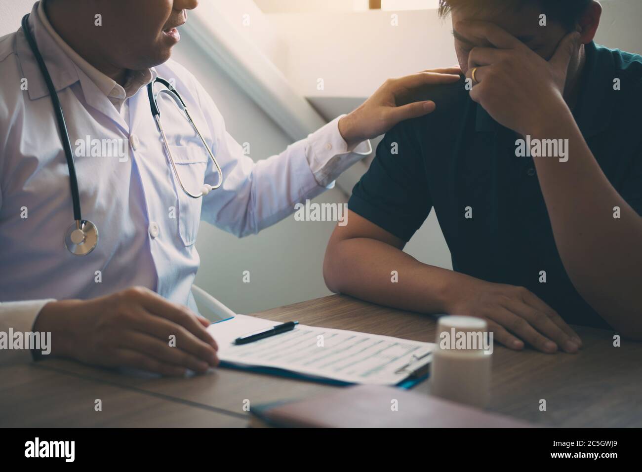 Doctor is comforting the patient after notifying the patient about the outcomes of treatment. Stock Photo