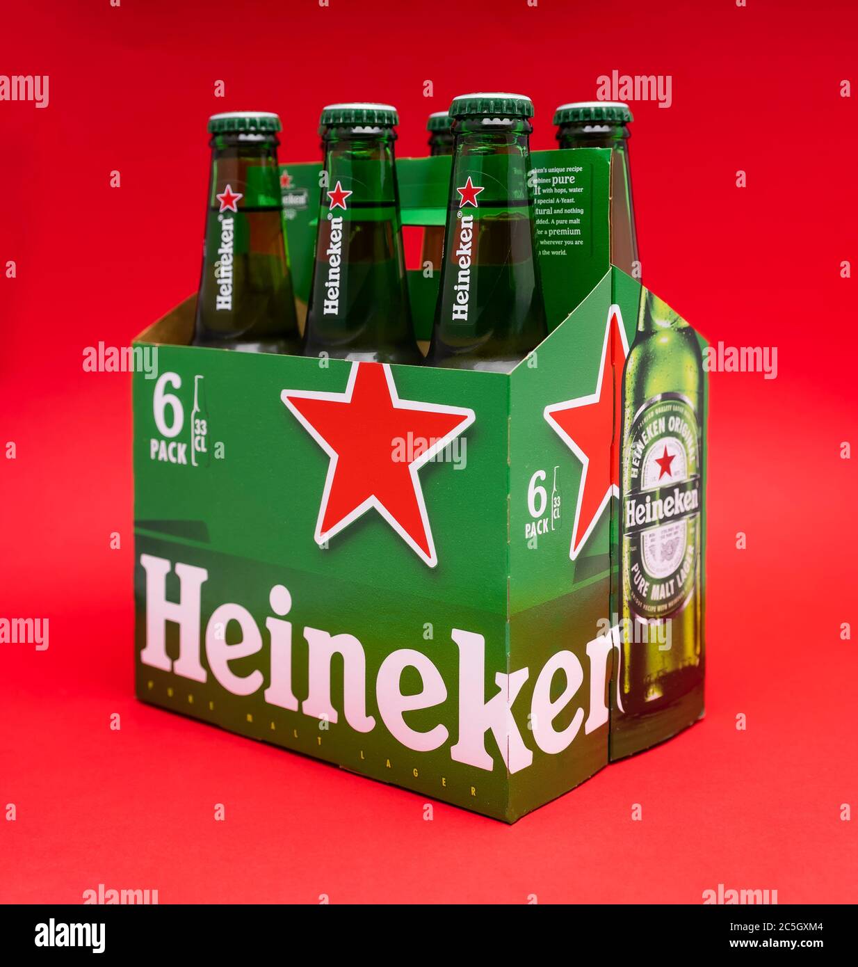 Sankt-Petersburg, Russia, Fenruary 02, 2020: Six pack of Heineken light lager beer on red background with one bottle on the foreground in focus studio Stock Photo