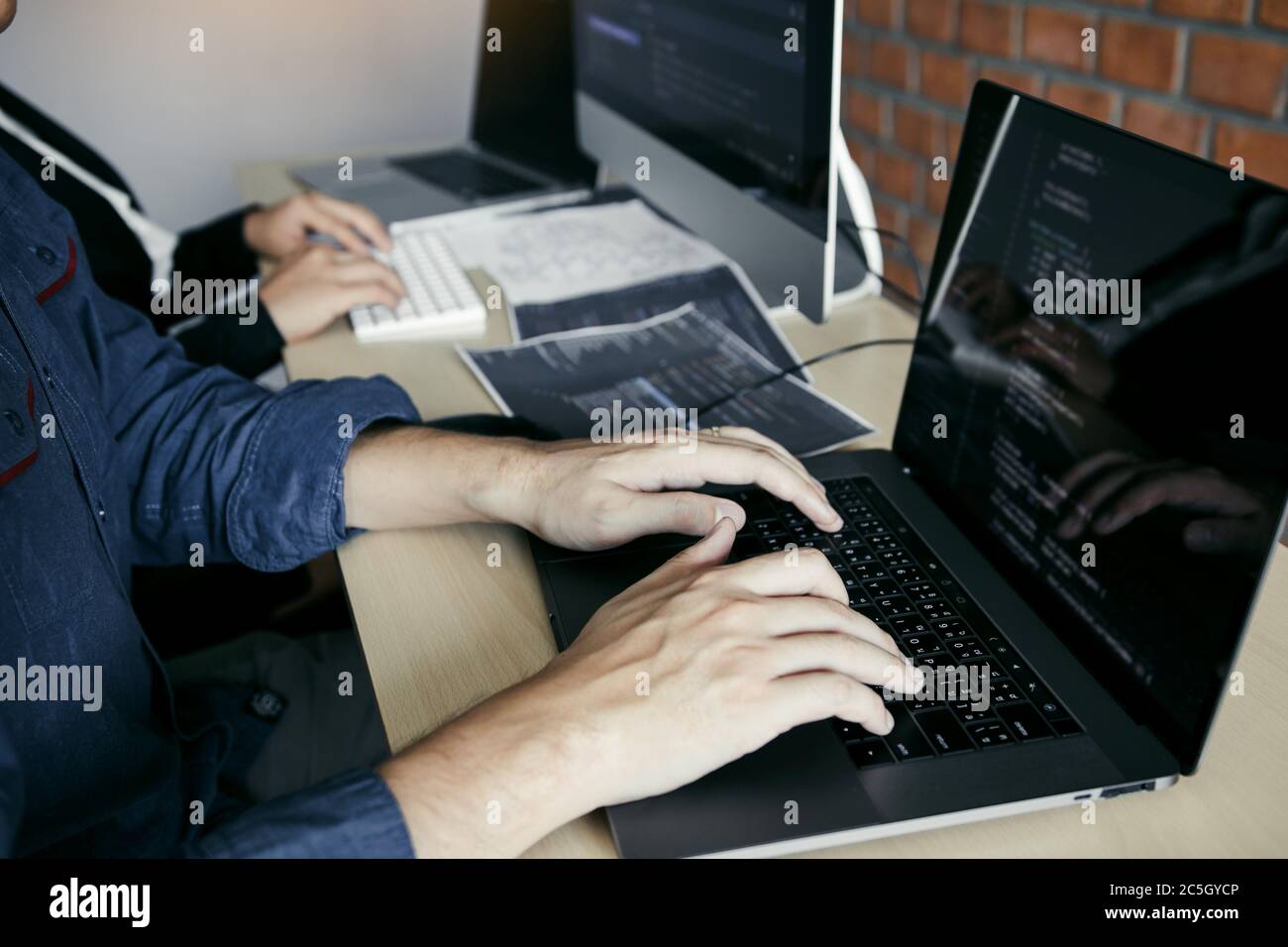 Two partnerships developing programming and coding technologies working on laptop and analyzing together. Stock Photo