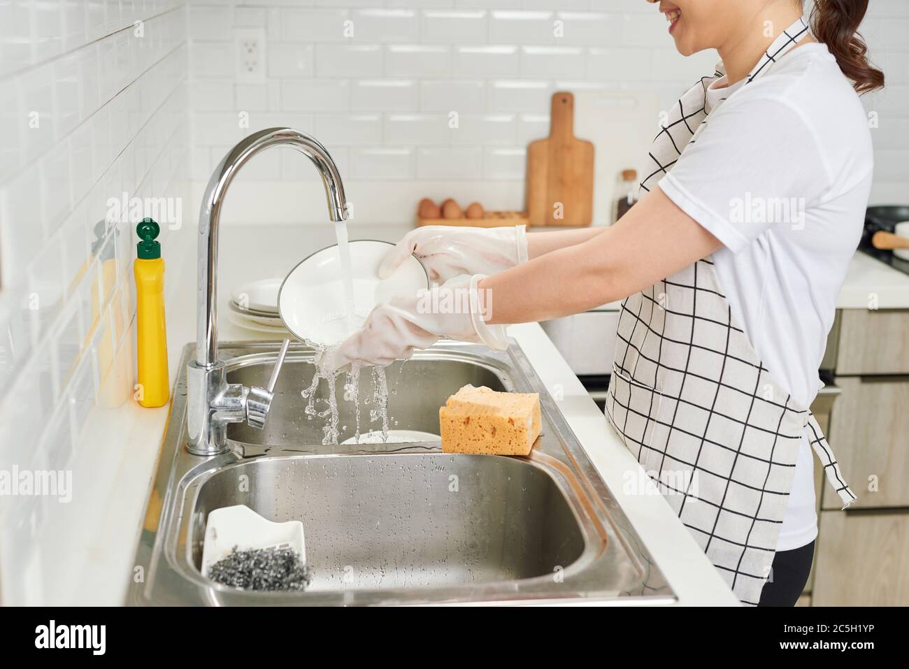 Caucasian woman washing dishes in kitchen Stock Photo - Alamy