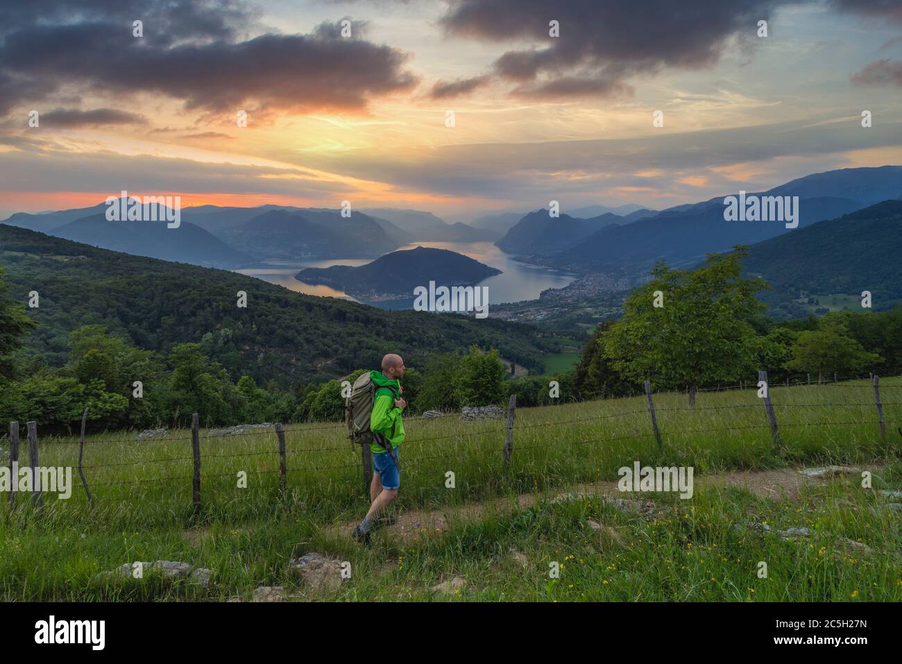 A man walks at Sunset over Iseo lake from Colmi di Polaveno, Polaveno, Brescia, Lombardy, Italy, Southern Europe Stock Photo