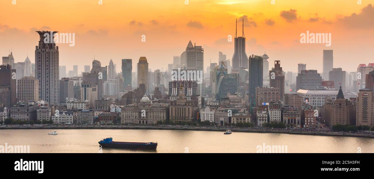Sunset / dawn at the Bund. Skyline of Shanghai Puxi with yellow sky. Panorama format. Stock Photo