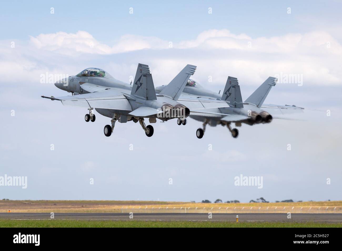 Two Royal Australian Air Force (RAAF) Boeing F/A-18F Super Hornet multirole fighter aircraft taking off in formation. Stock Photo