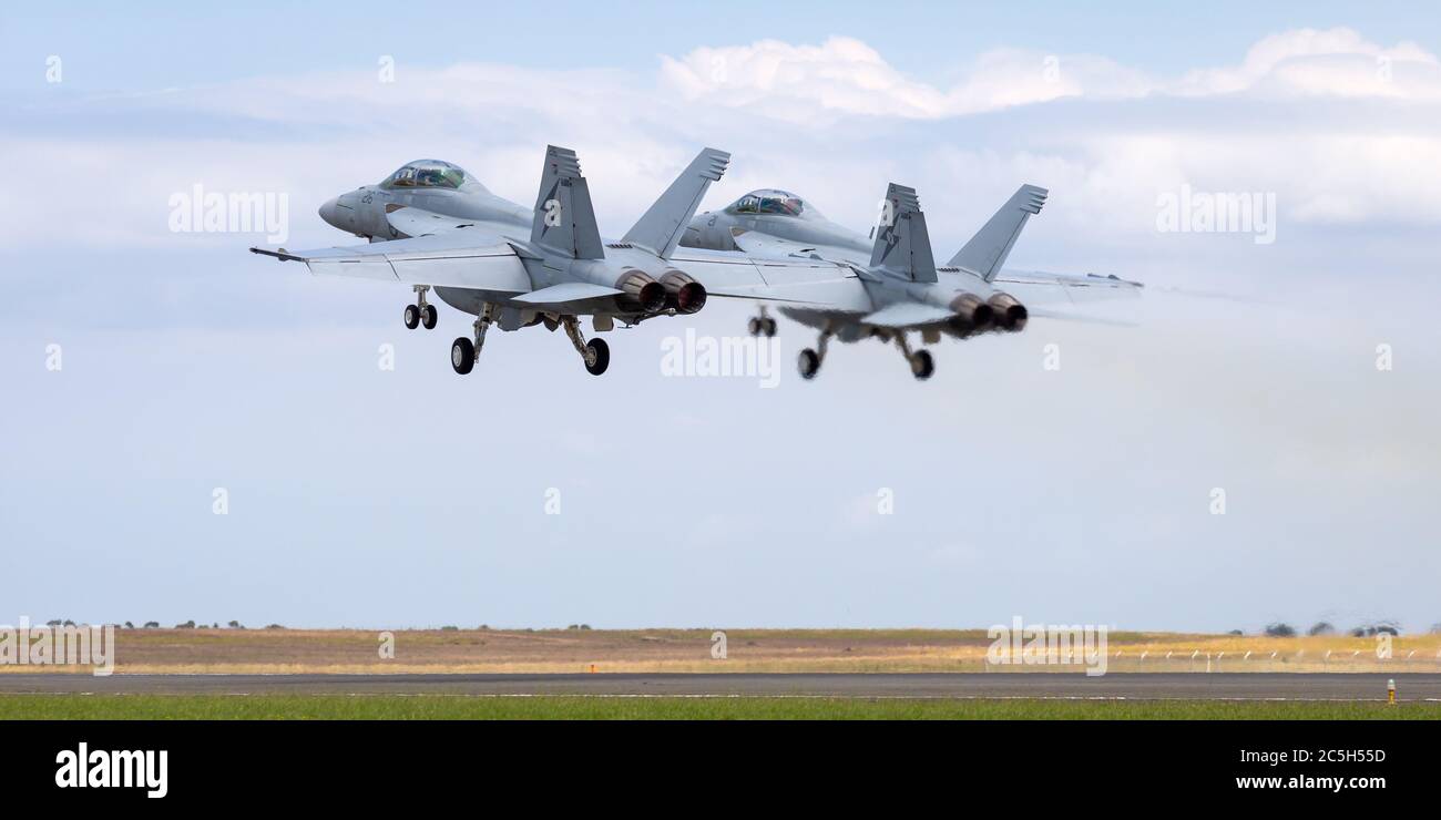 Two Royal Australian Air Force (RAAF) Boeing F/A-18F Super Hornet multirole fighter aircraft taking off in formation. Stock Photo