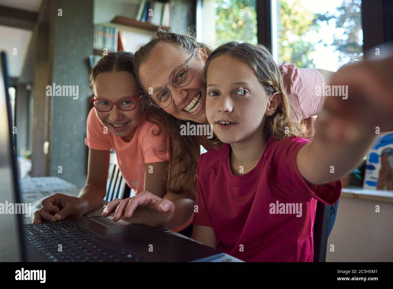 Mother helping for two girls infront of the laptop Stock Photo