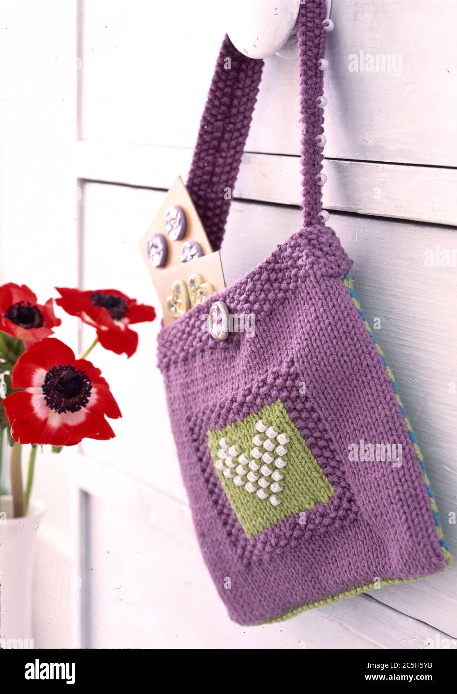 Mauve crochet bag hanging on chest handle Stock Photo