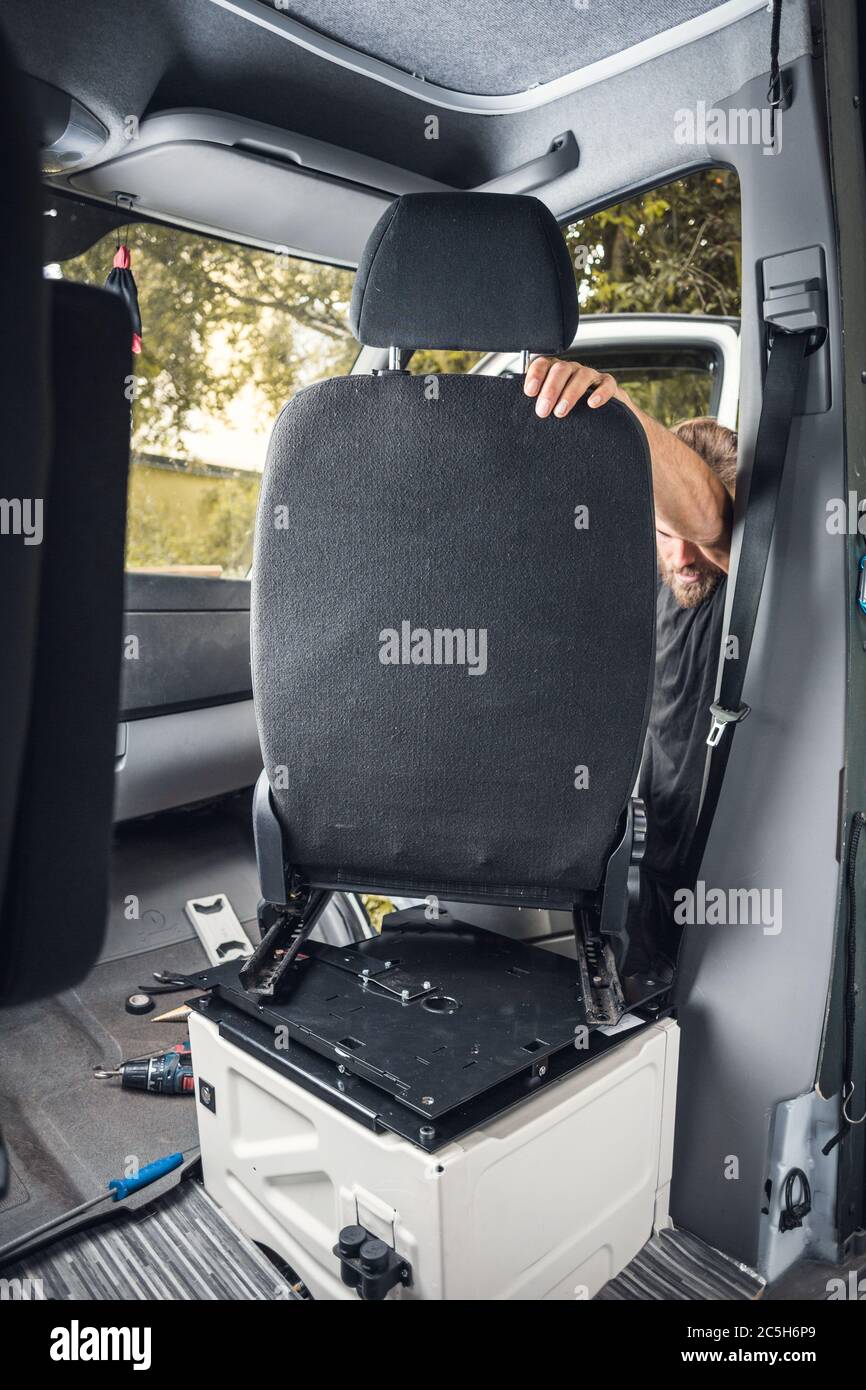 Man installing a swivel seat in his caravan Stock Photo