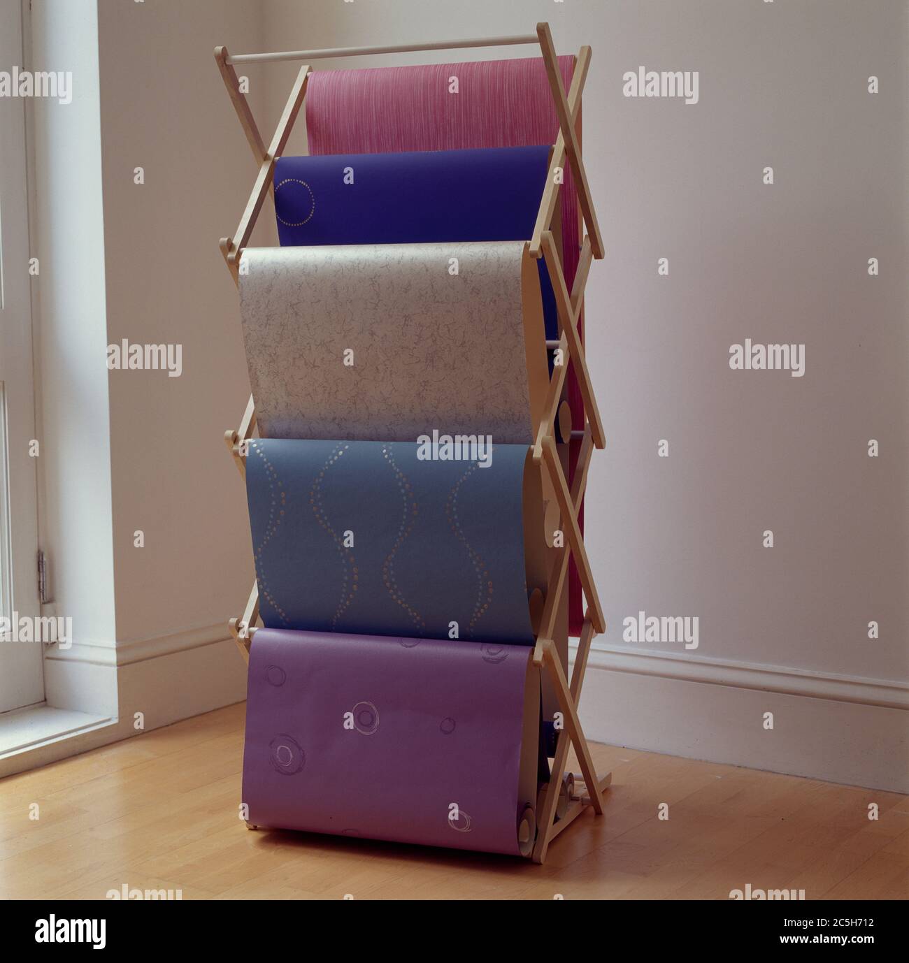 Samples of various wallpapers hung on clothes rack for viewing Stock Photo Alamy