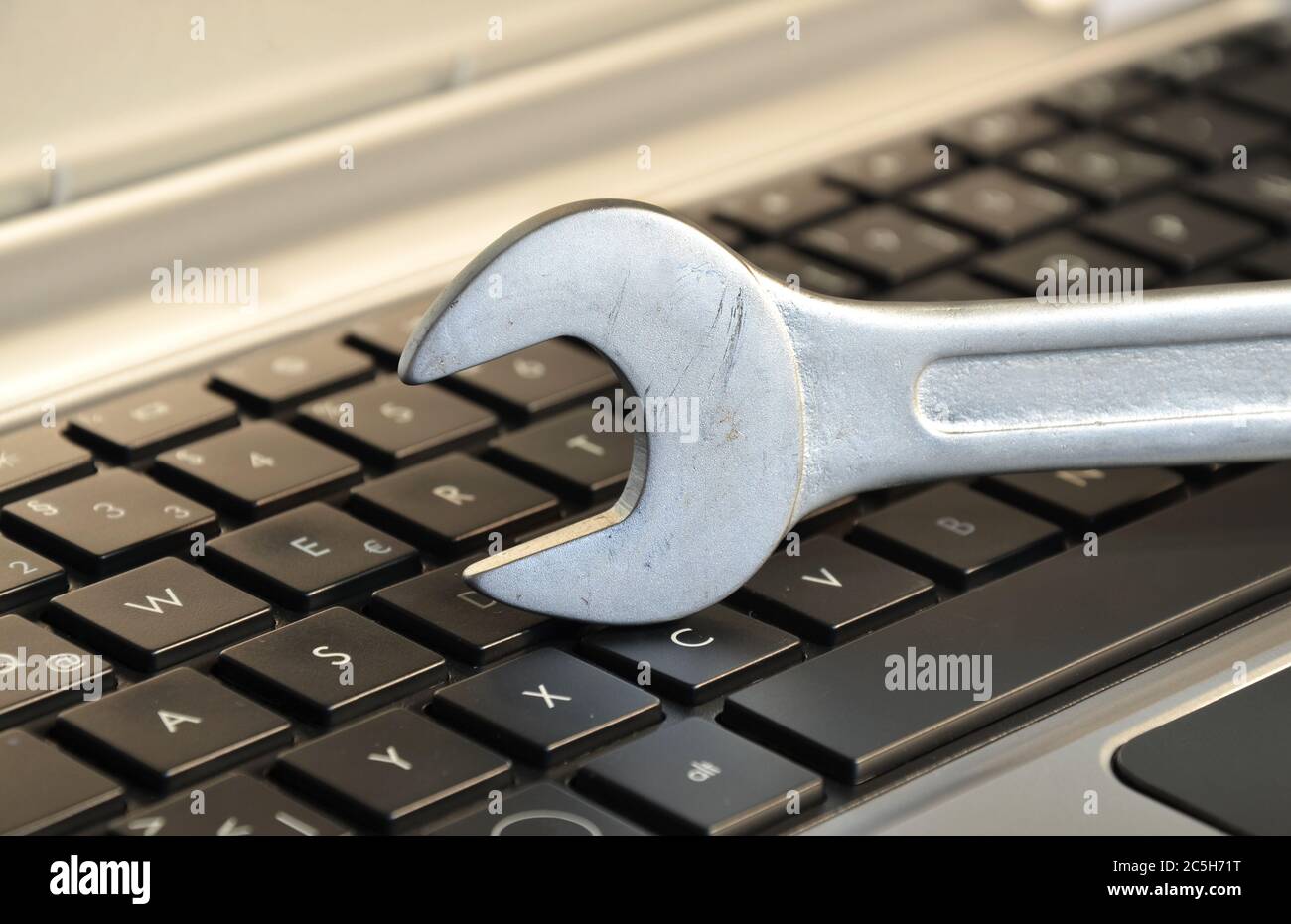 Wrench lying on keyboard symbolizing computer maintenance Stock Photo