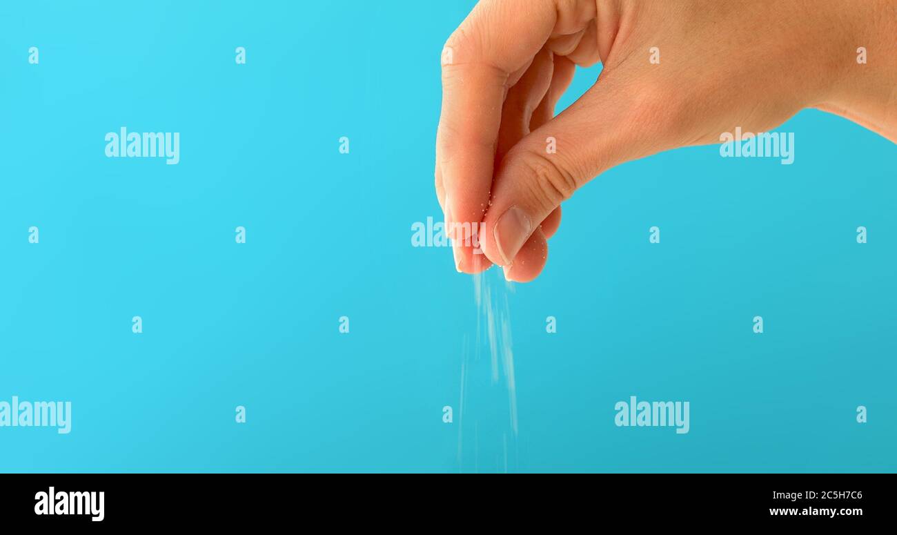 hand cooking food and adding white coarse salt Stock Photo Alamy