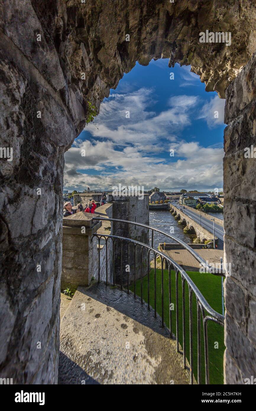 View trough archway to Limerick city wall and Thormond bridge in summer Stock Photo