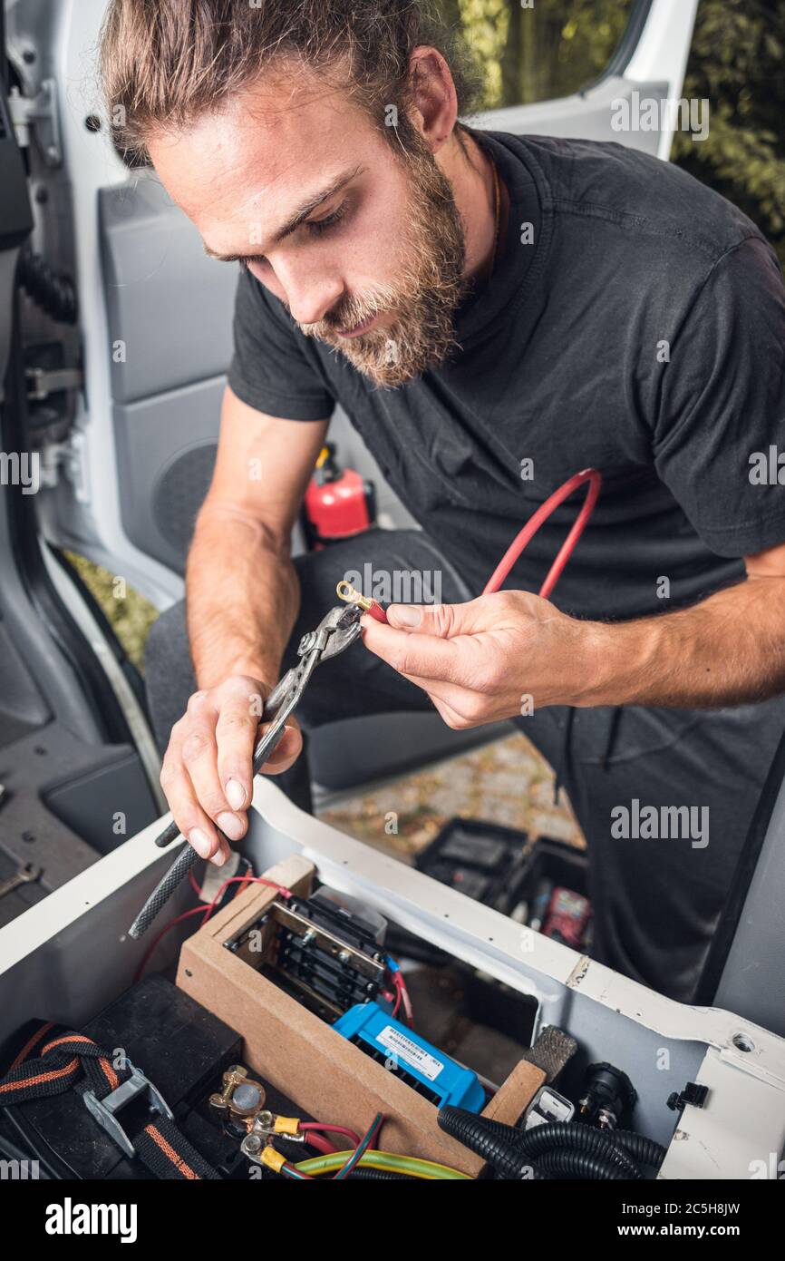 Man working on electronics inside his camper van Stock Photo Alamy