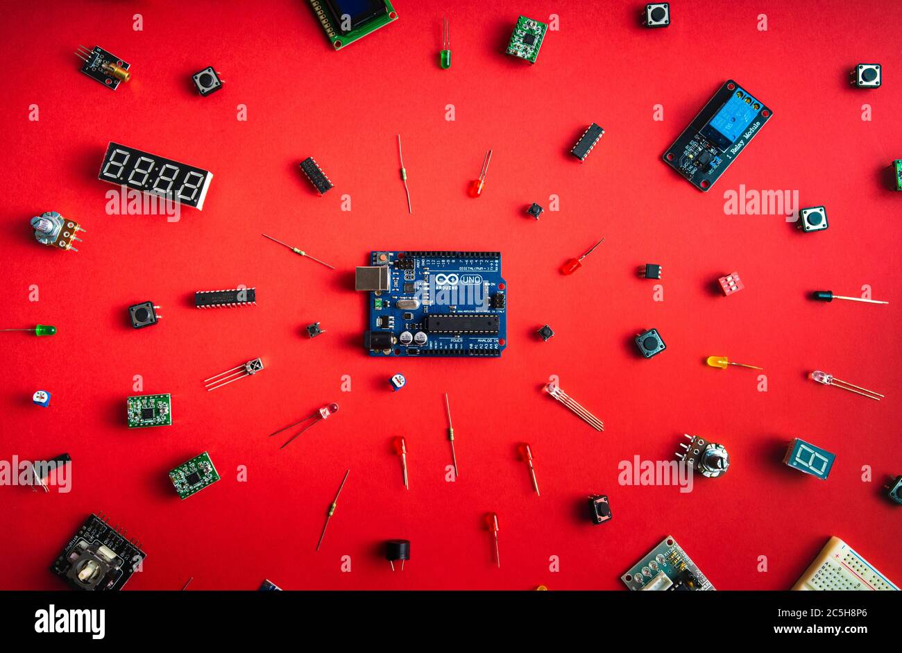 Sankt-Petersburg, Russia - February 28, 2020: Arduino UNO board over red background. Microcontrollers, boards, sensors, leds, controllers, Microcontro Stock Photo