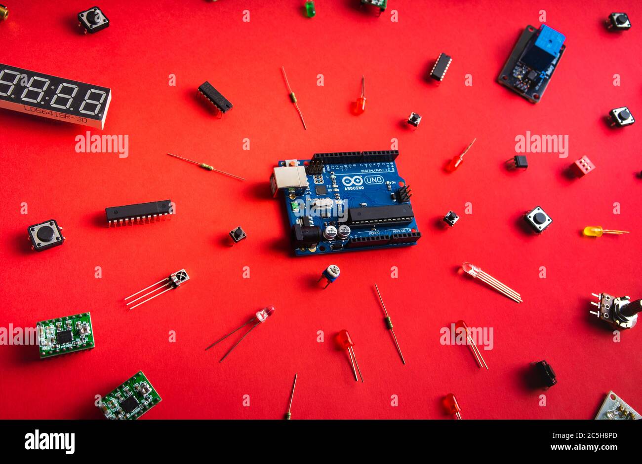 Sankt-Petersburg, Russia - February 28, 2020: Arduino UNO board over red background. Microcontrollers, boards, sensors, leds, controllers, Microcontro Stock Photo