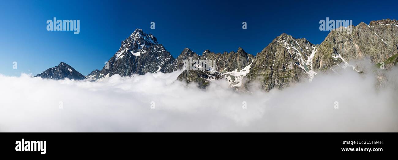 Mountain ridges and peaks of the Alps emerging over the clouds ...