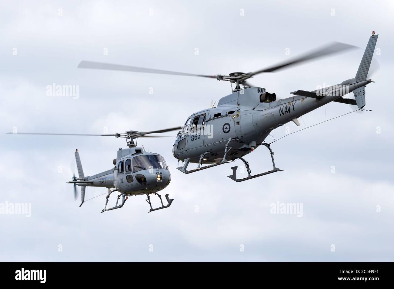 Royal Australian Navy Aerospatiale AS-350B Helicopters (N22-001 & N22-016) from HMAS Albartoss flying in close formation. Stock Photo