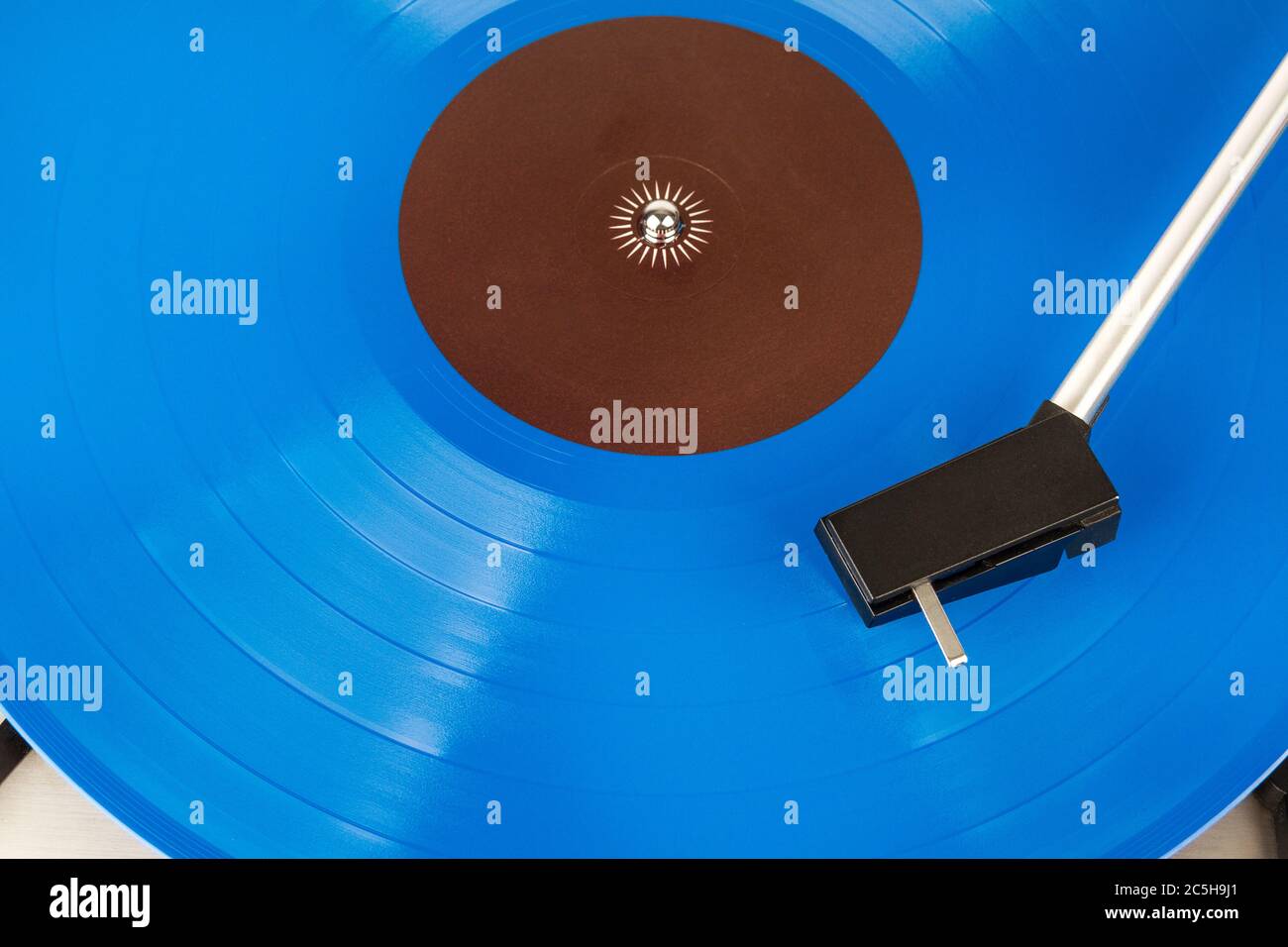 Close up of turntable cartridge on a vinyl record. Turntable playing vinyl. Needle on rotating