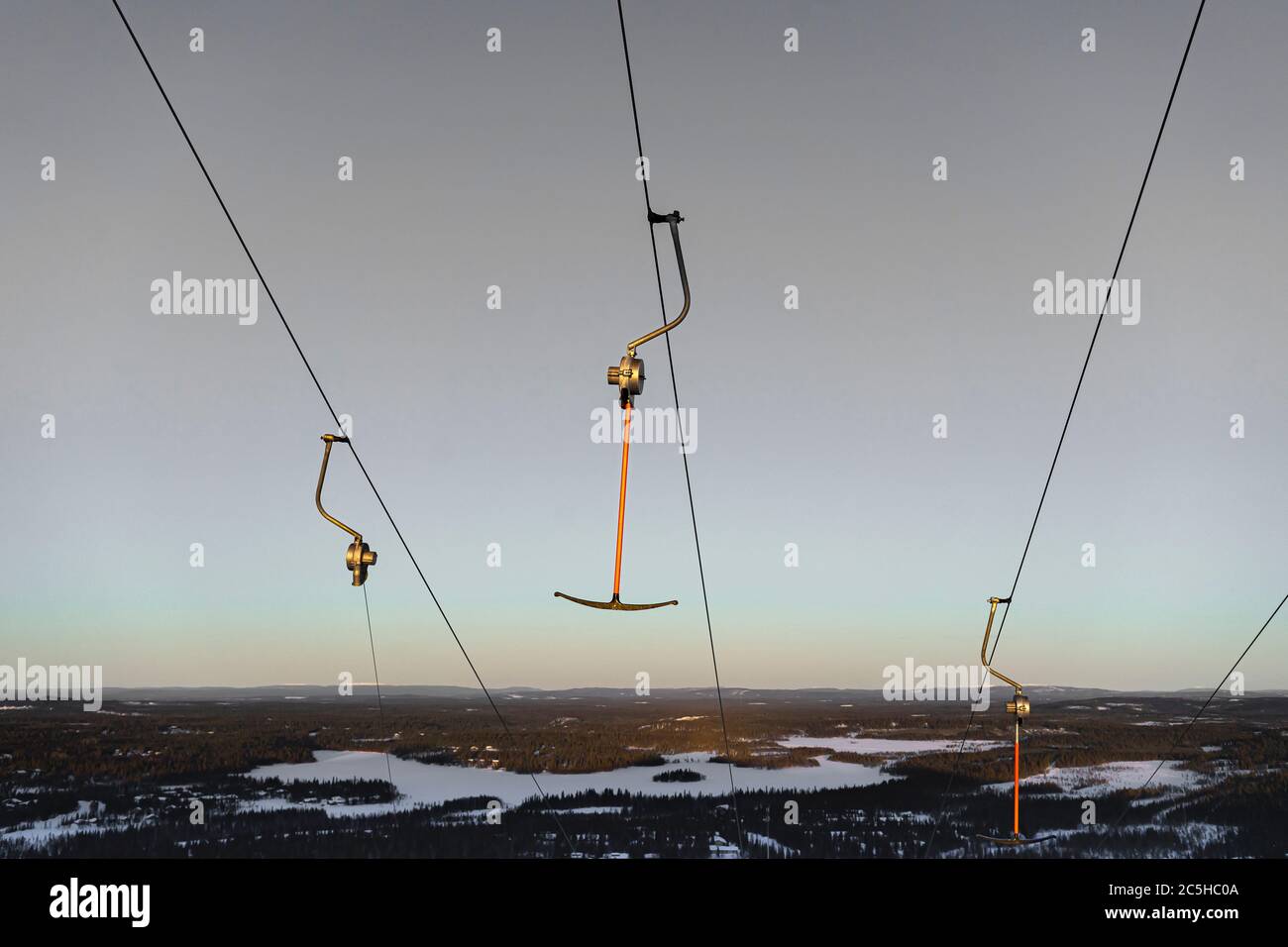 Hooks are hanging on a lift cable in a ski resort in winter with a beautiful sunset sky Stock Photo