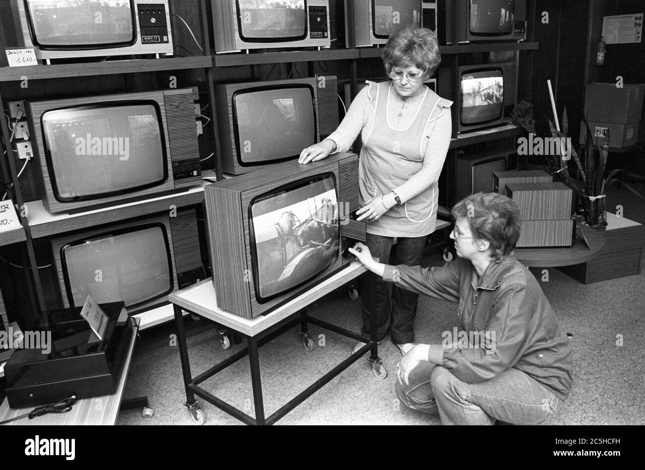 30 November 1988, Saxony, Eilenburg: In a RFT shop in Eilenburg in the mid-1980s, sales assistants (buyers) inspect a used television set and prepare it for resale. Exact date of recording not known. Photo: Volkmar Heinz/dpa-Zentralbild/ZB Stock Photo