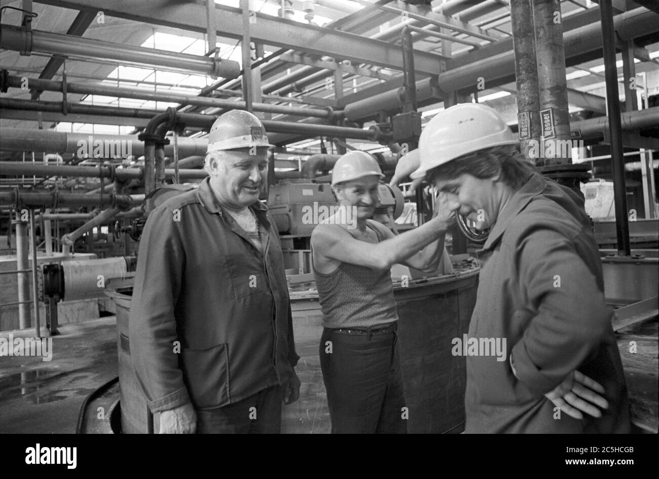 30 November 1986, Saxony, Eilenburg: Members of a brigade from the "water sector" from the VEB Eilenburger Chemiewerk (ECW) are talking amidst pipe systems. Exact date of recording not known. Photo: Volkmar Heinz/dpa-Zentralbild/ZB Stock Photo