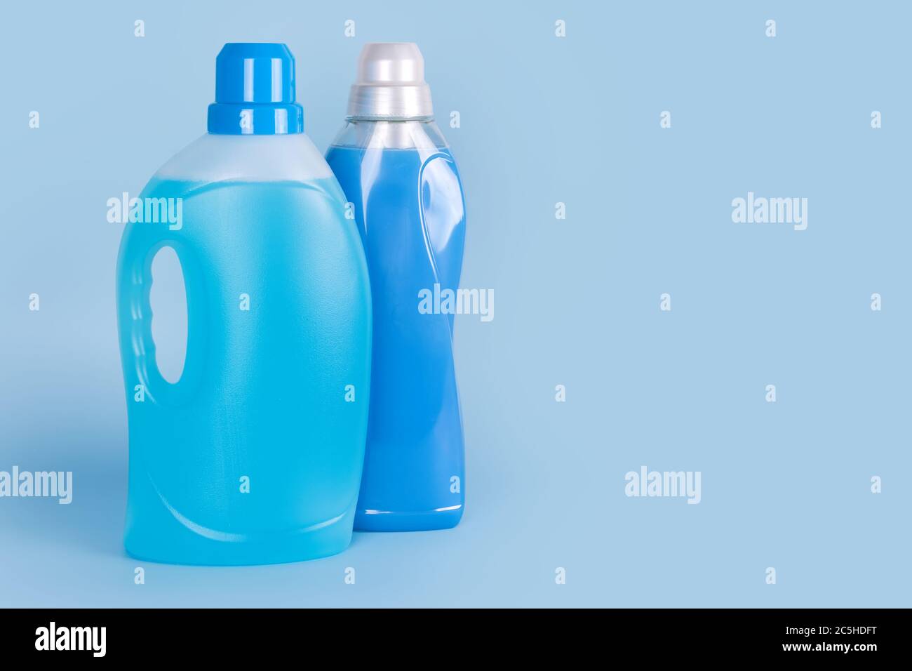 Bottles of detergent and fabric softener on blue background. Containers