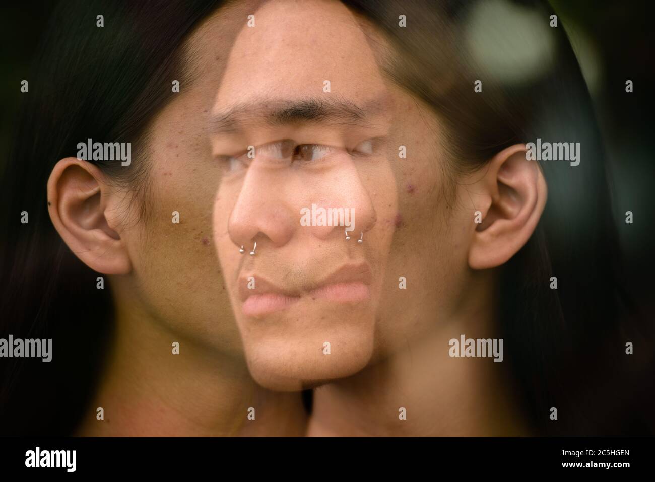 Young Asian man with long hair in the city with multiple exposure