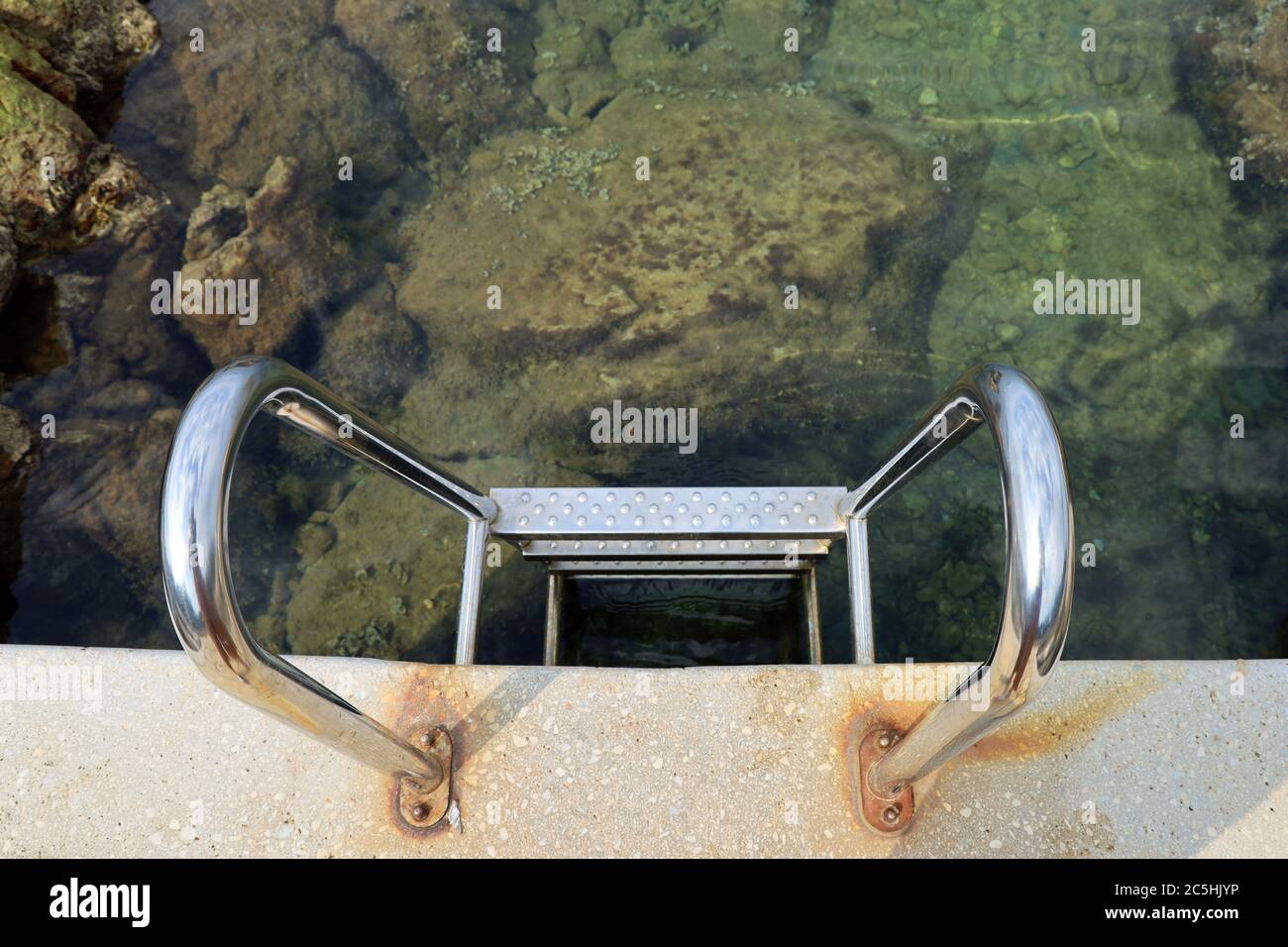 top view of a metal stairs leading into the sea water Stock Photo