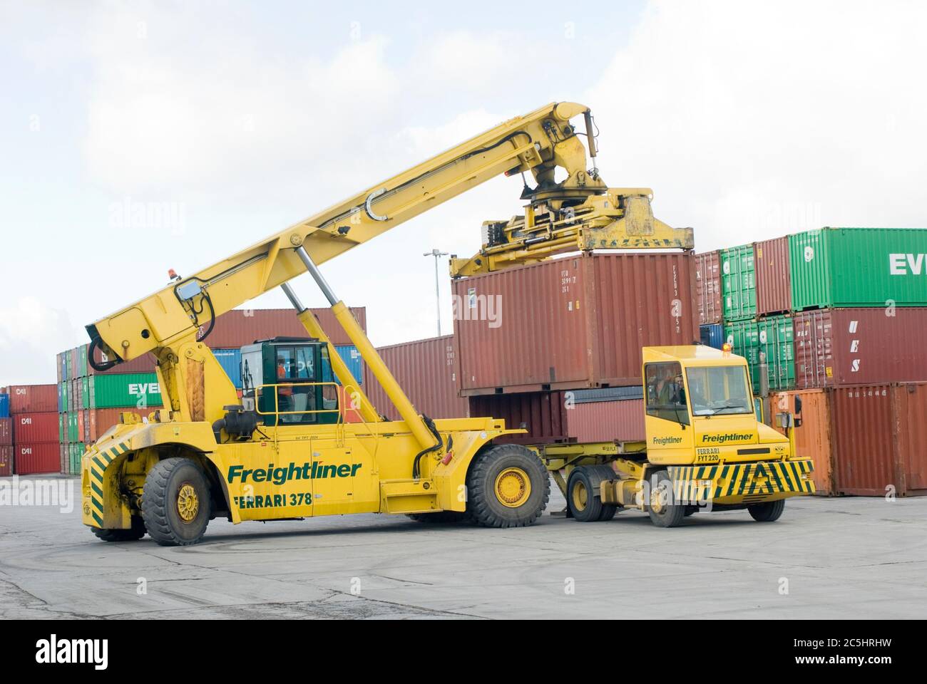 CVS Ferrari reach stacker and terminal tractor being used to move shipping containers at Manchester Euroterminal, Trafford Park, Manchester, England. Stock Photo