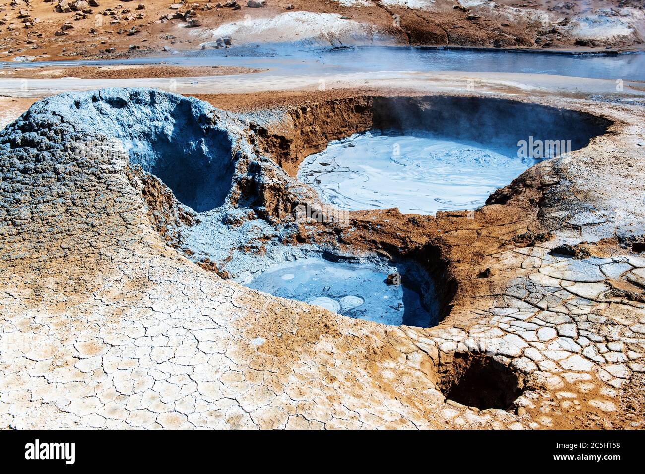 Mudpots in the geothermal area Hverir, Iceland. The area around the boiling mud is multicolored and cracked Stock Photo - Alamy
