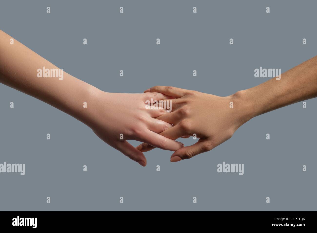 Closeup of people from different races interlocking fingers Stock