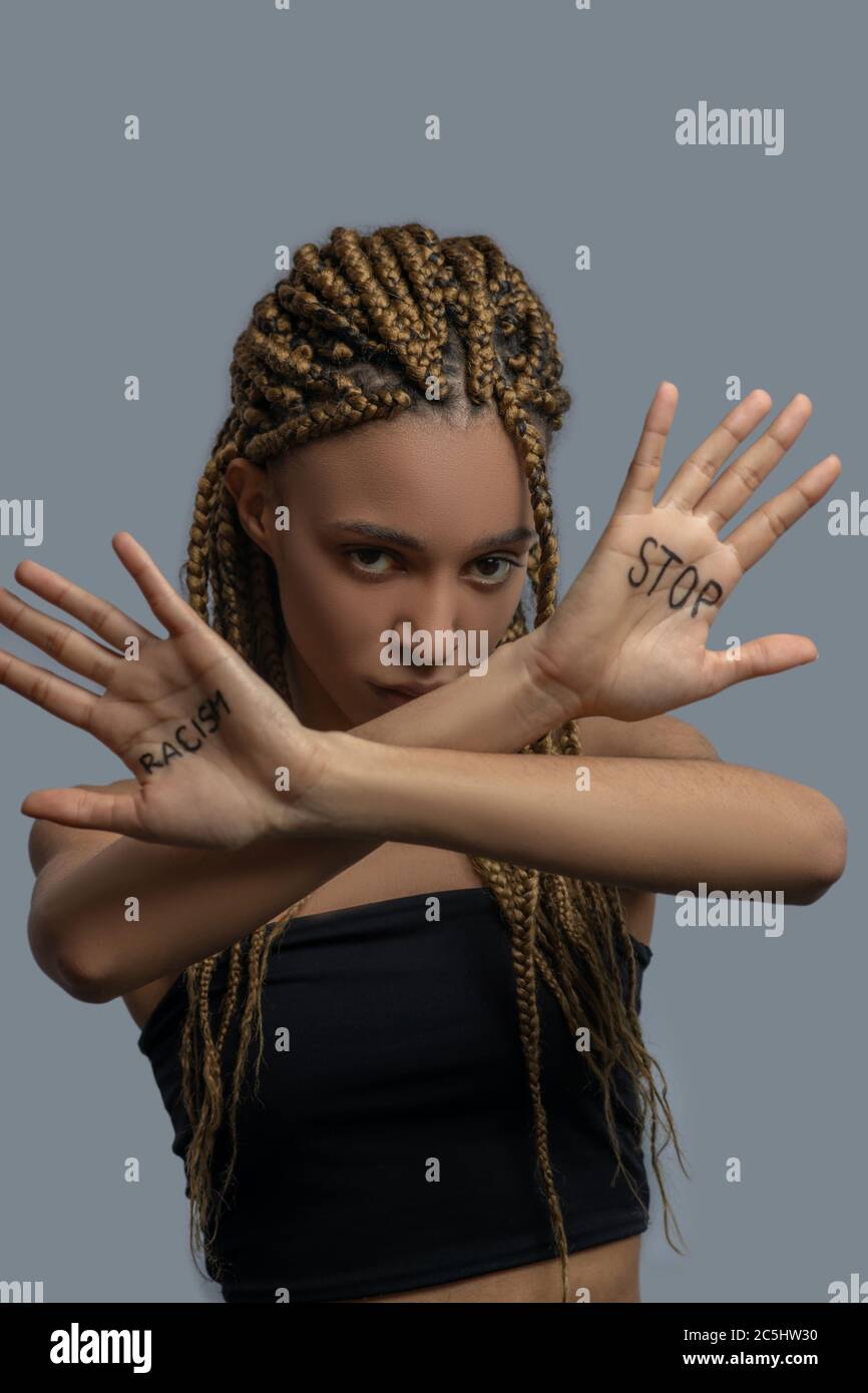 Sad young African American woman making cross with arms, showing palm with stop racism lettering Stock Photo