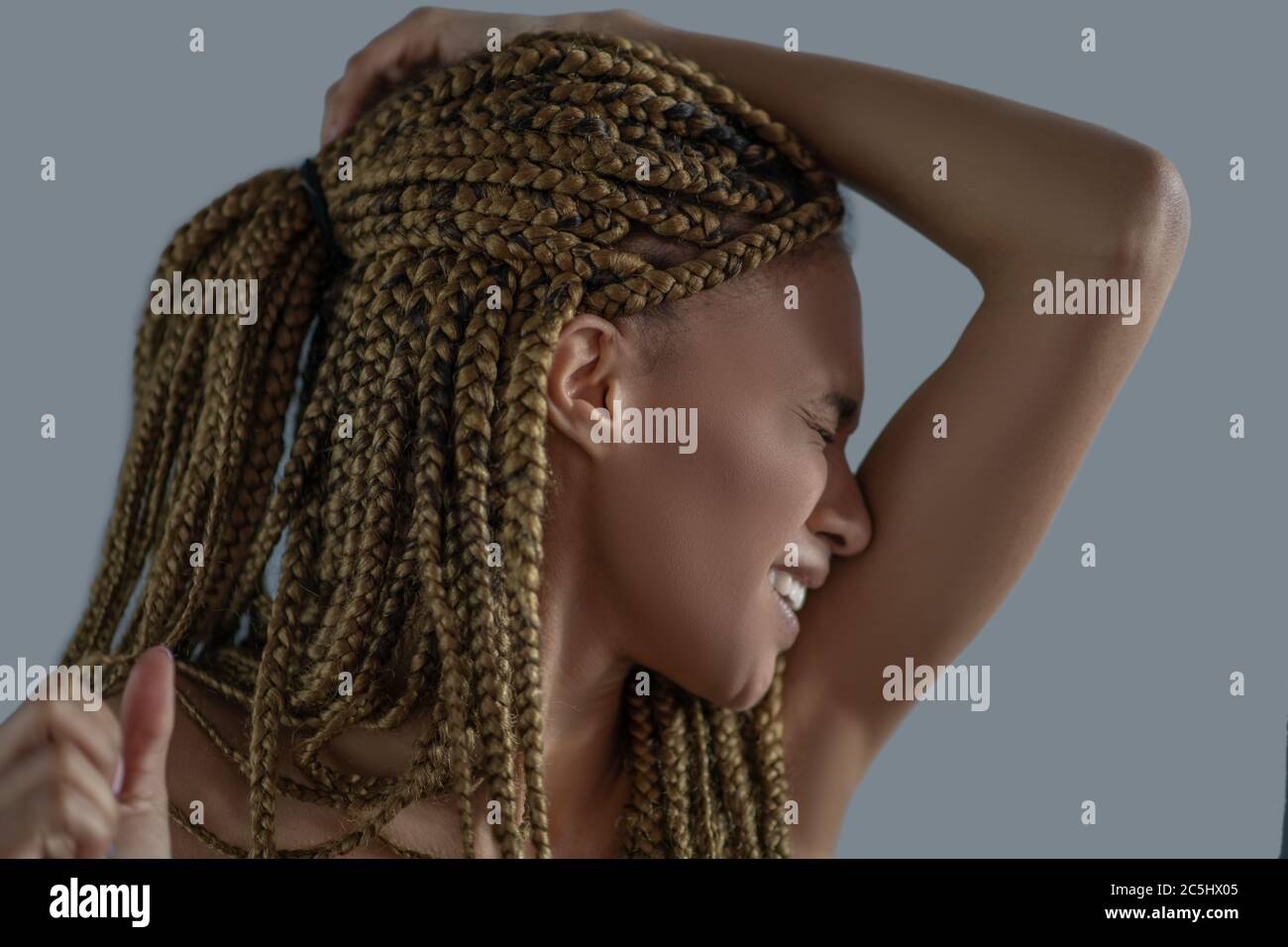 Devastated young African American holding her head with one arm, frowning with pain Stock Photo