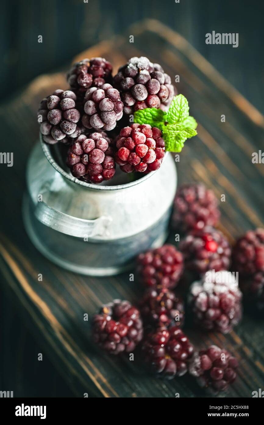 Frozen blackberries on a wooden table. Vertical. Stock Photo