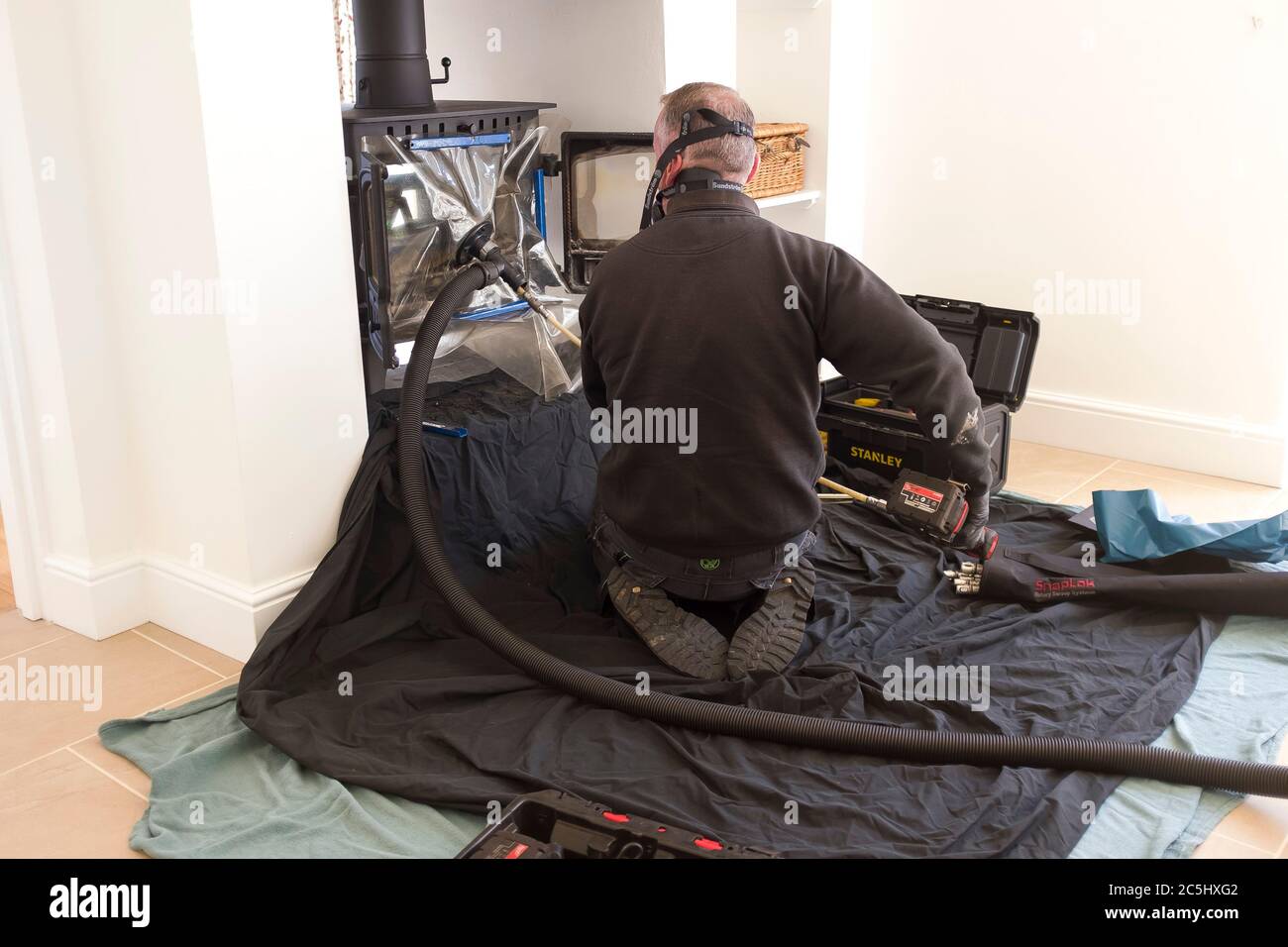BUCKINGHAM, UK - April 20, 2020. Modern chimney sweep sweeping chimney with a flue liner in a home, UK Stock Photo